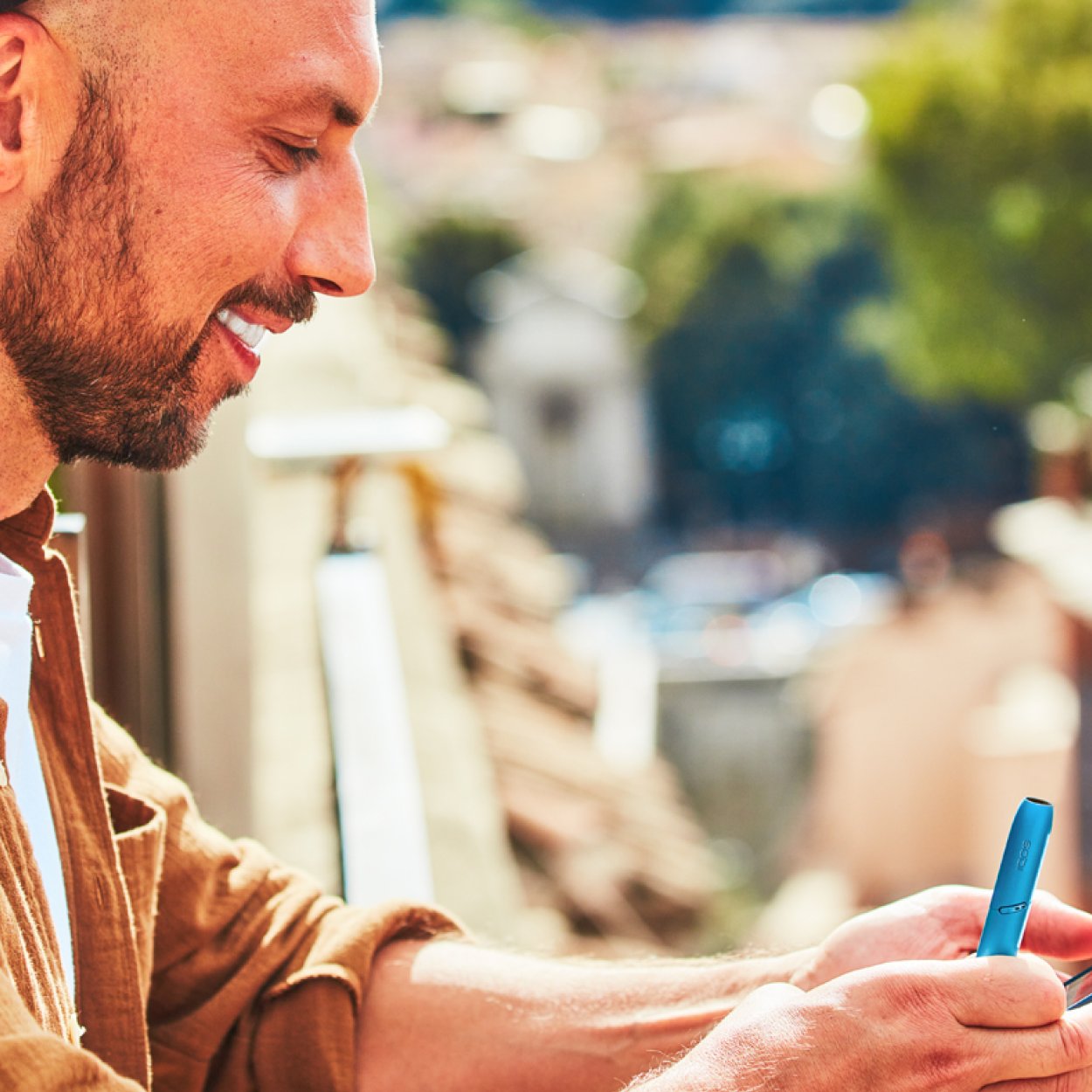 A man is holding IQOS 3 device