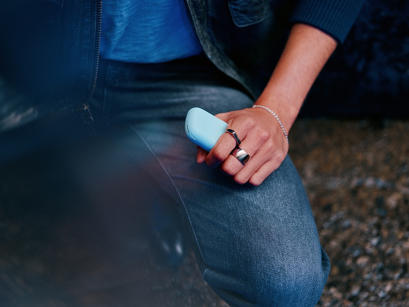 A person holding an IQOS ILUMA i PRIME color Breeze Blue in their hand