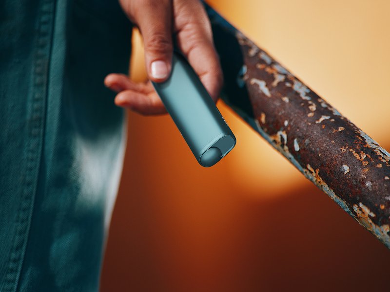 Persona sosteniendo un IQOS ILUMA i ONE color Breeze Blue en su mano