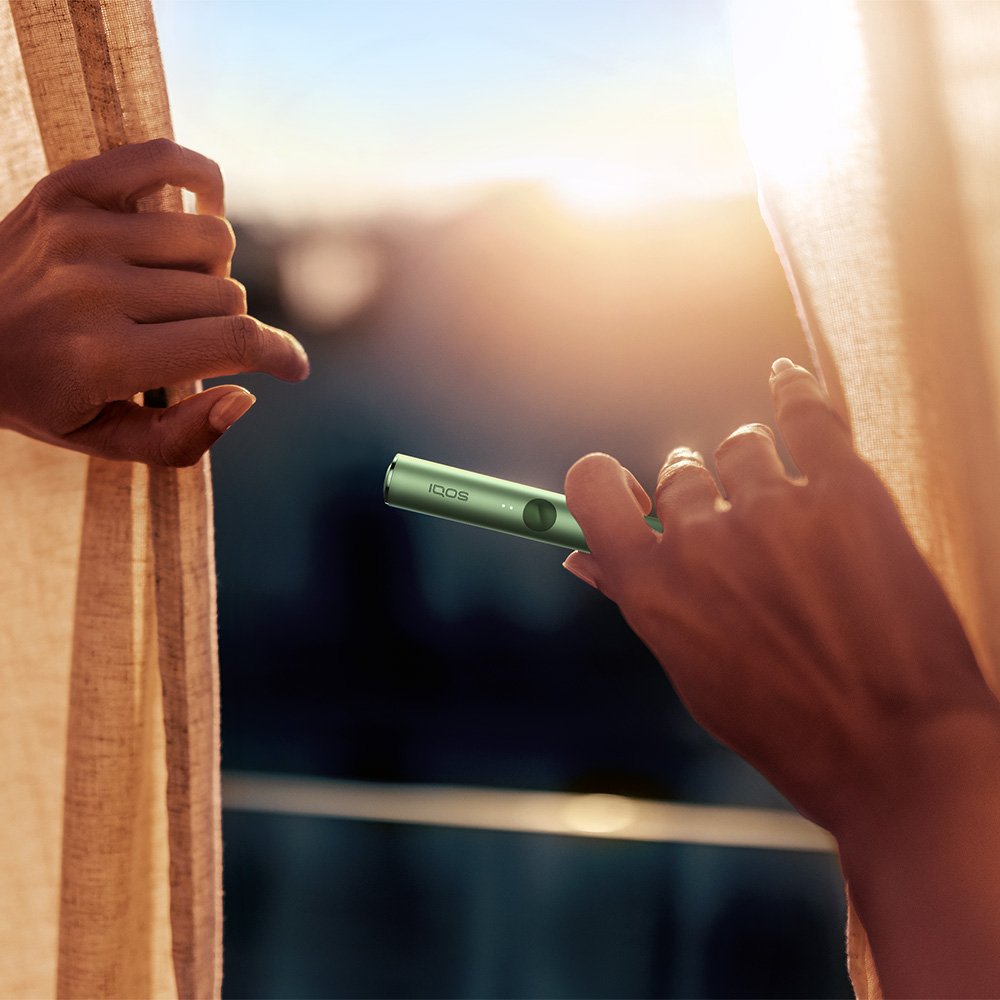 Two friends holding IQOS devices