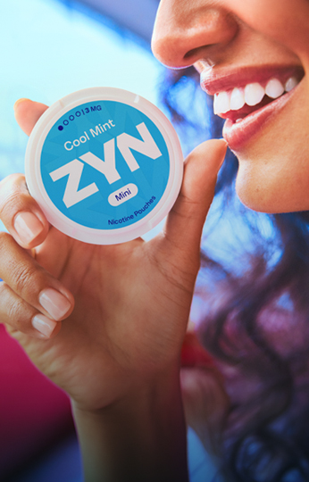 ZYN Flavors - Woman smiling while keeping blue ZYN Cool Mint nicotin pouch