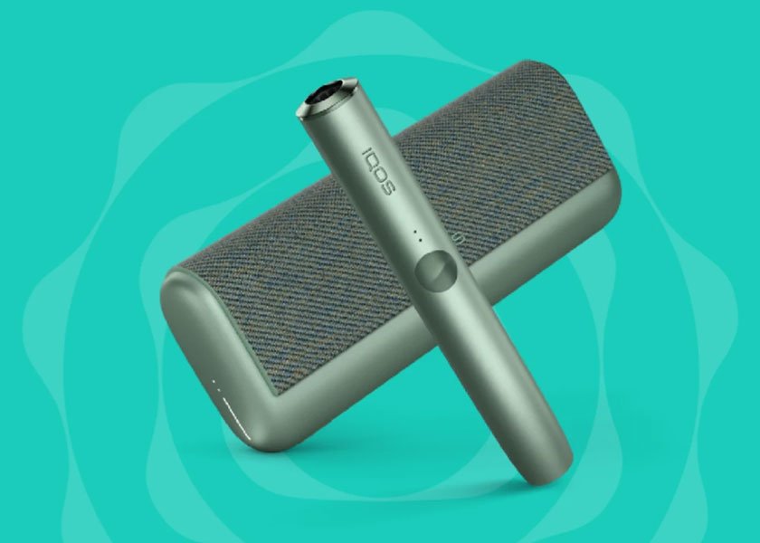 Zařízení IQOS ILUMA PRIME na tyrkysovém pozadí