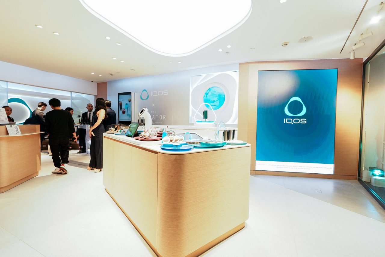 Modern IQOS boutique in Glorietta display featuring digital screens with innovation messaging and illuminated IQOS branding elements.
