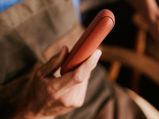 Man's hands holding brilliant gold IQOS 3 DUO holder and charger