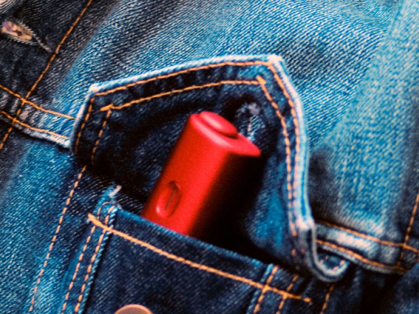 Un appareil BONDS by IQOS rouge glissé dans la poche d'une veste en jean