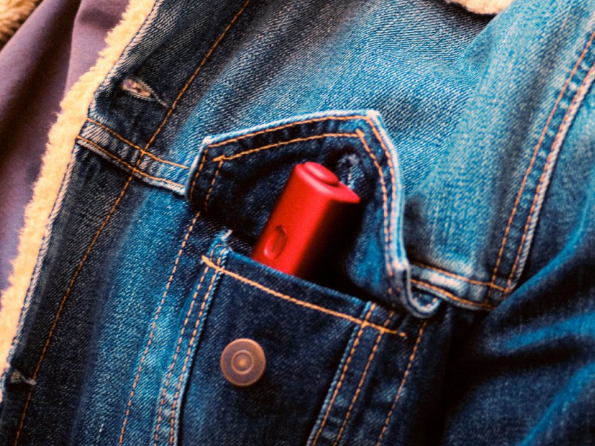 Un appareil BONDS by IQOS rouge glissé dans la poche d'une veste en jean