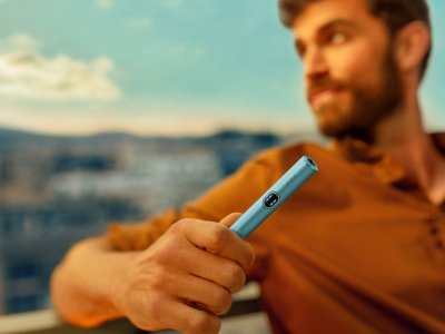 Muž držící zařízení IQOS ILUMA i v barvě Breeze Blue