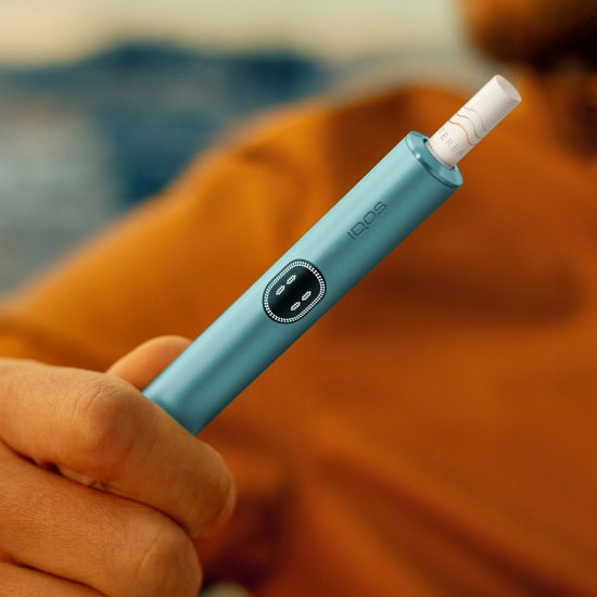 Hand holding an IQOS ILUMA i device