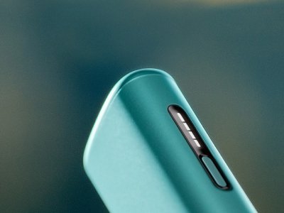 Gros plan zoomé sur les voyants lumineux de l'appareil IQOS ILUMA i ONE (appareil tout-en-un) couleur Aigue Marine, sur un fond dégradé bleu foncé