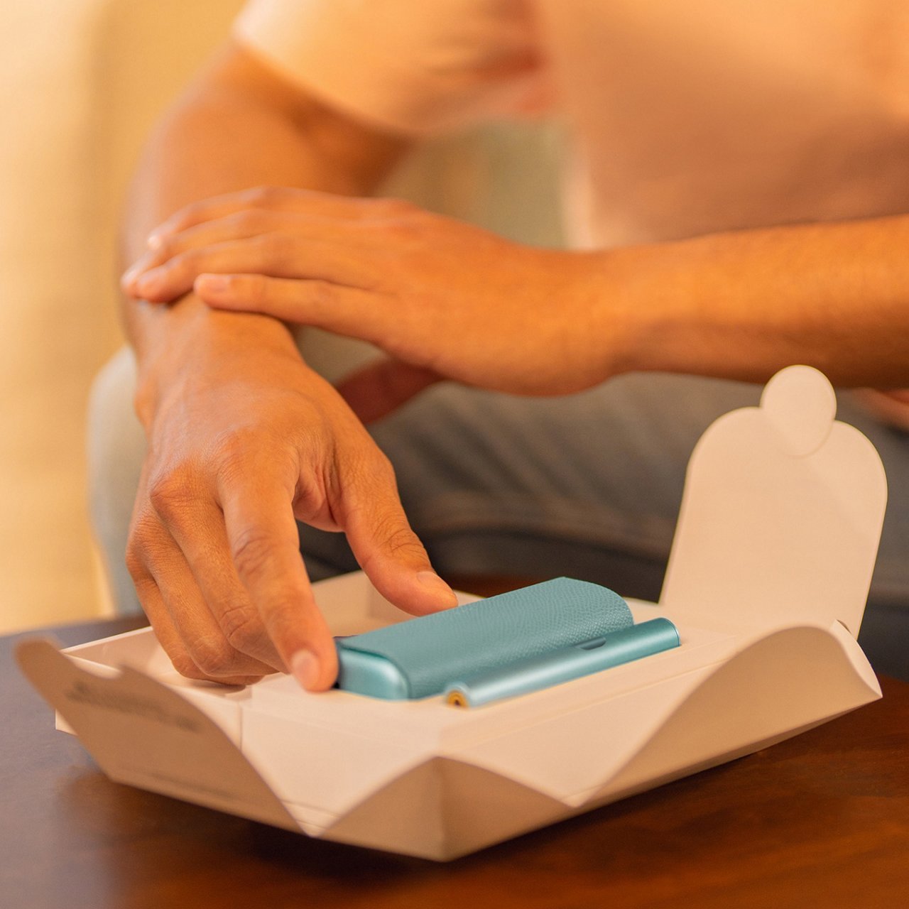Hands unboxing an IQOS ILUMA i PRIME device
