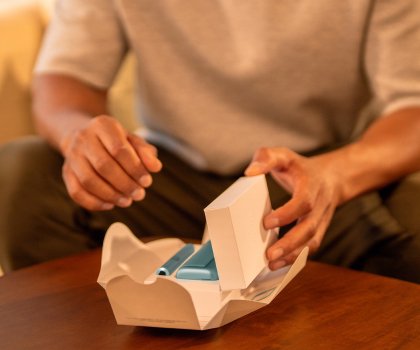 Person unboxing an IQOS ILUMA i device