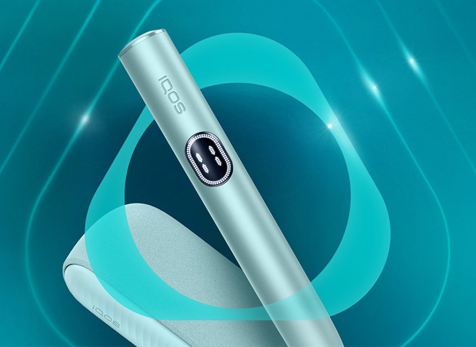 Appareil IQOS ILUMA i couleur aigue-marine posé sur un fond dégradé bleu