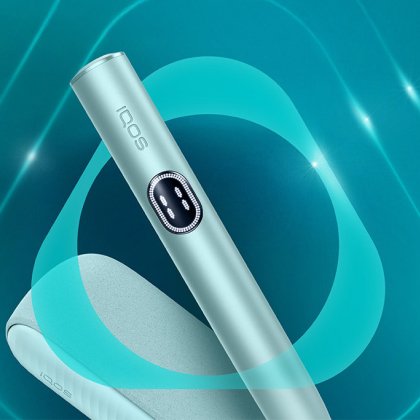 Appareil IQOS ILUMA i couleur aigue-marine posé sur un fond dégradé bleu