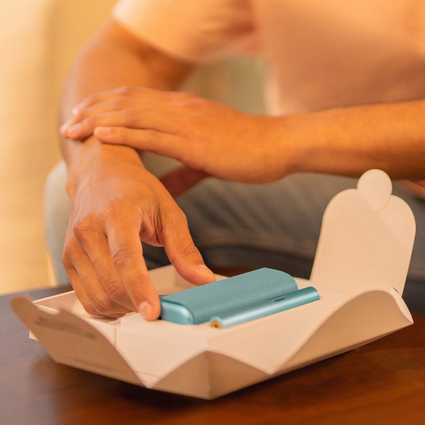 Hands unboxing an IQOS ILUMA i PRIME device