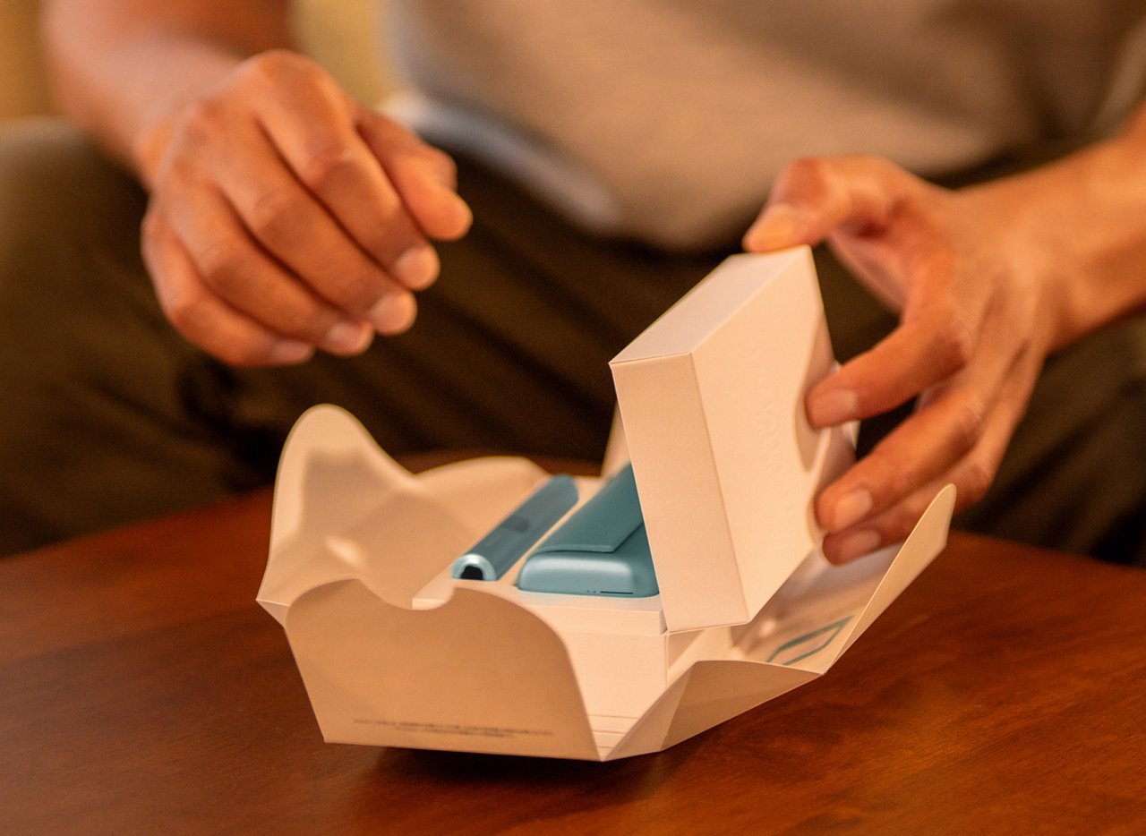 Руки распаковывают устройство IQOS ILUMA i PRIME