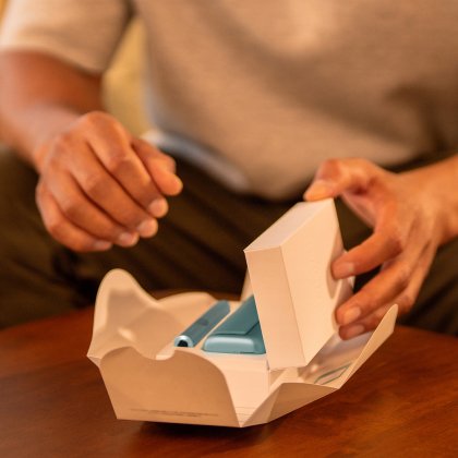 Руки распаковывают устройство IQOS ILUMA i PRIME