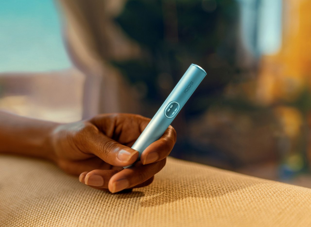 Рука держит устройство IQOS ILUMA