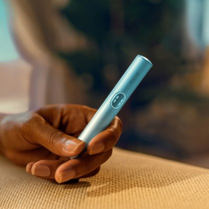 Рука держит устройство IQOS ILUMA