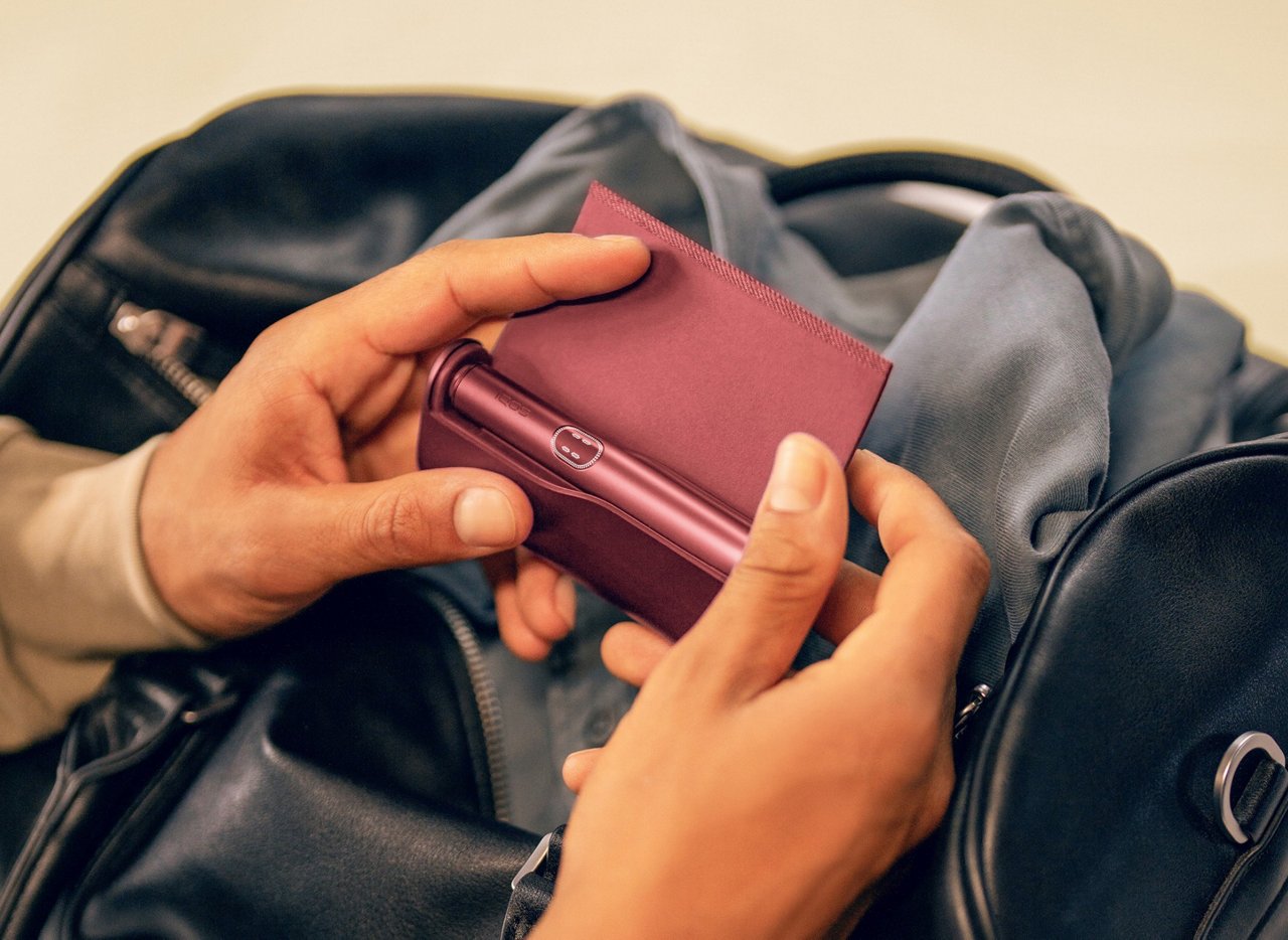 يدان تفتحان غلاف جهاز IQOS ILUMA i PRIME