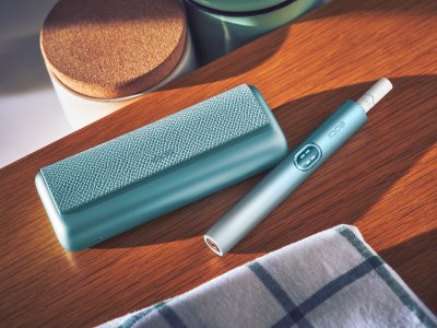 Breeze Blue IQOS ILUMA i Prime holder and charger on brown desk
