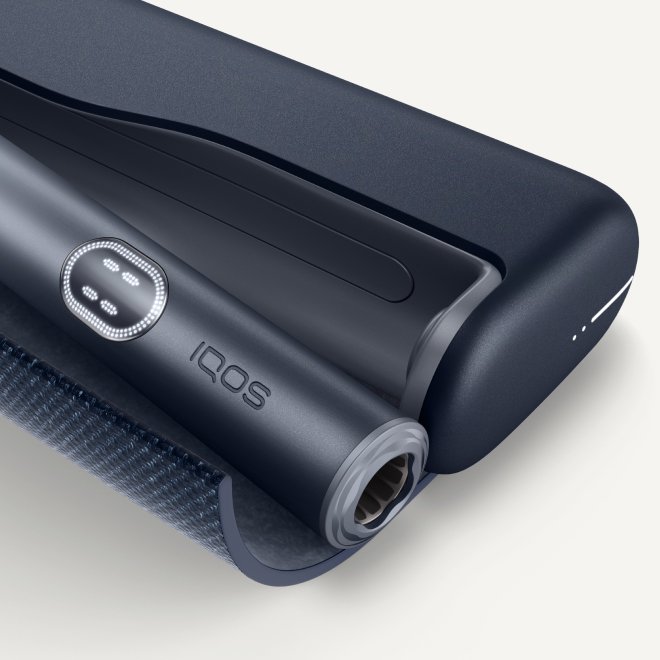 Das Bild zeigt ein IQOS ILUMA i PRIME in der Farbe Midnight Black - ein modernes, elegantes Tabakerhitzungsgerät mit einer glatten Oberfläche und einem strukturierten Griffbereich.