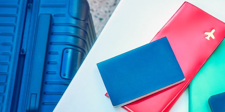 Ein Tisch mit Reisedokumenten und einem IQOS ILUMA Prime Holder und Charger.