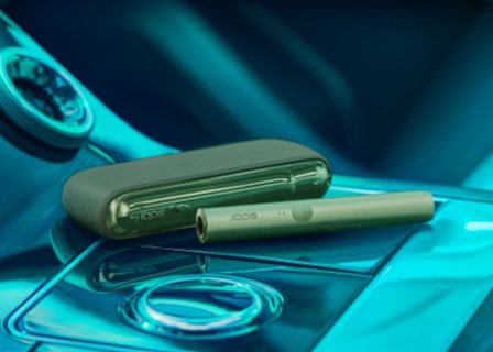 جهاز وشاحن IQOS ILUMA باللون الأخضر.