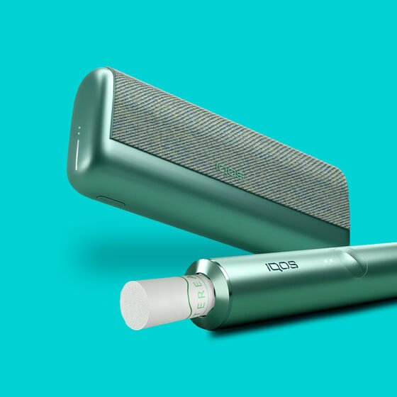 A jade green IQOS ILUMA PRIME device with a TEREA stick inserted.
