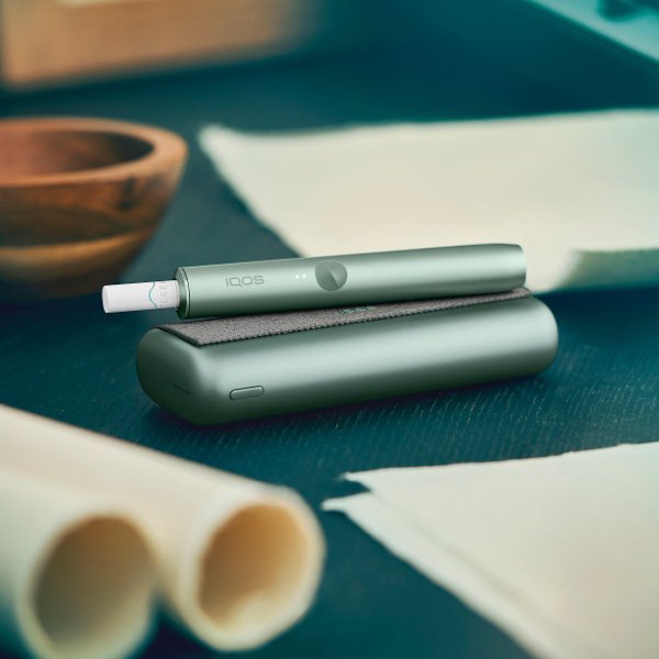 ILUMA PRIME Holder Jade Green liegt auf Pocket Charger Jade Green.