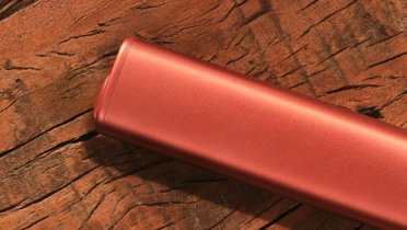 IQOS ILUMA i ONE naprava v Terracota color na mizi
