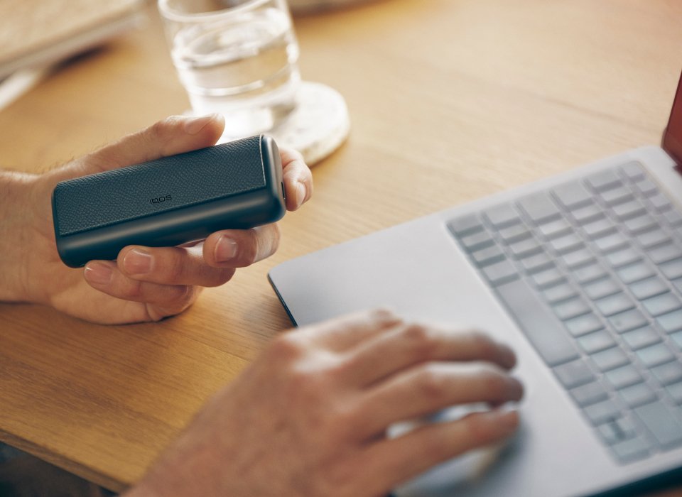  A person performs online diagnostics on a black IQOS ILUMA charger