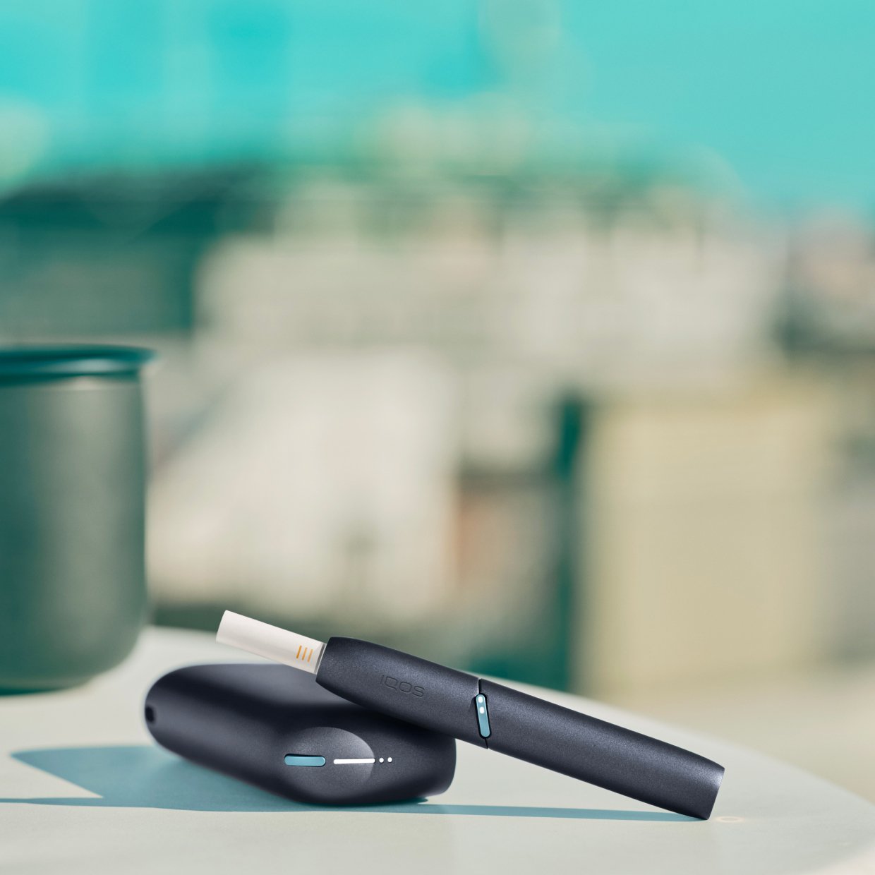 IQOS Originals Duo Holder und Pocket Charger in Slate auf einem Tisch