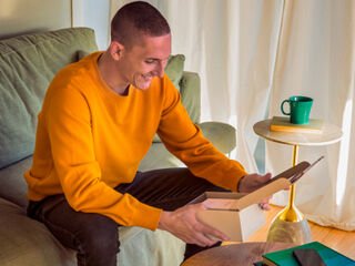 Man opening an IQOS Originals Duo device box, to discover all benefits of MyIqos.