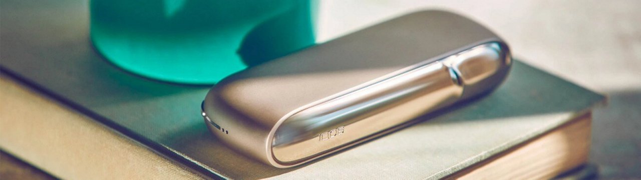 Zariadenie IQOS ILUMA ležiace na stole