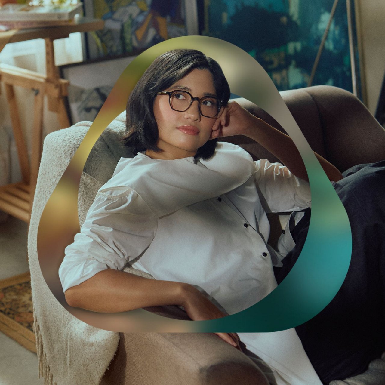 Creative studio scene featuring collaborator artist Isabel Santos relaxing on a sofa, surrounded by art materials.