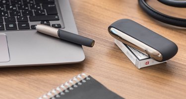 White IQOS 2.4 kit on the table of a bar