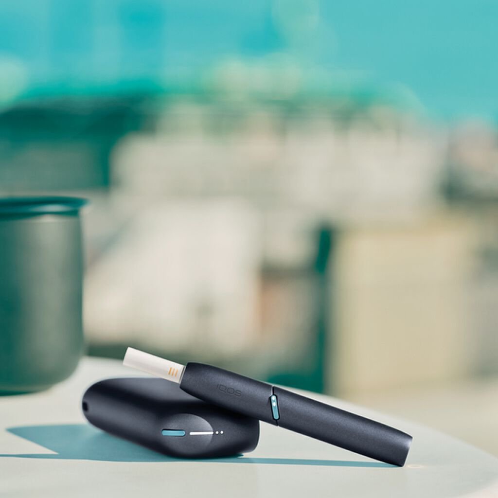 IQOS Originals Duo  holder and pocket charger on table.