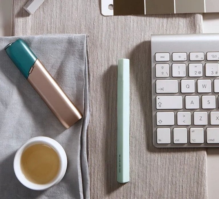 Green and coppery IQOS 3 Multi kit on a working desk