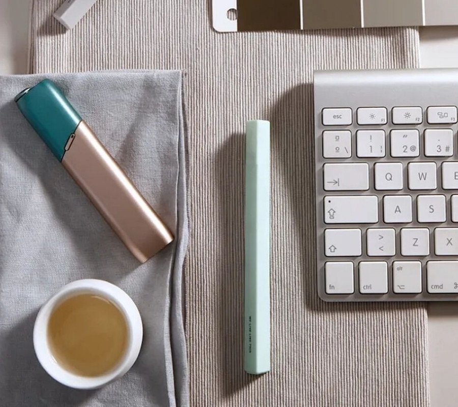 Green and coppery IQOS 3 Multi kit on a working desk