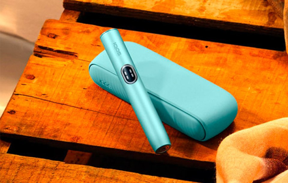 IQOS Iluma i couleur aigue marine posée sur table en bois