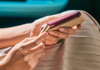 Man's hands holding brilliant gold IQOS 3 DUO holder and charger