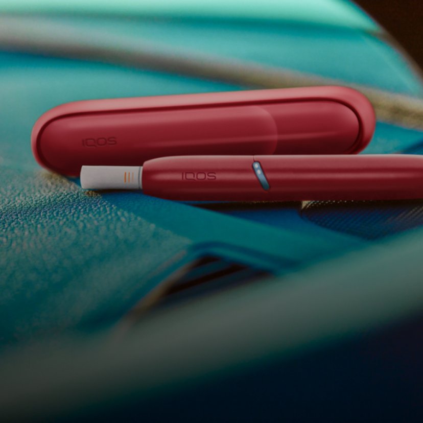 IQOS Originals Duo holder with HEETS stick and pocket charger in red color.