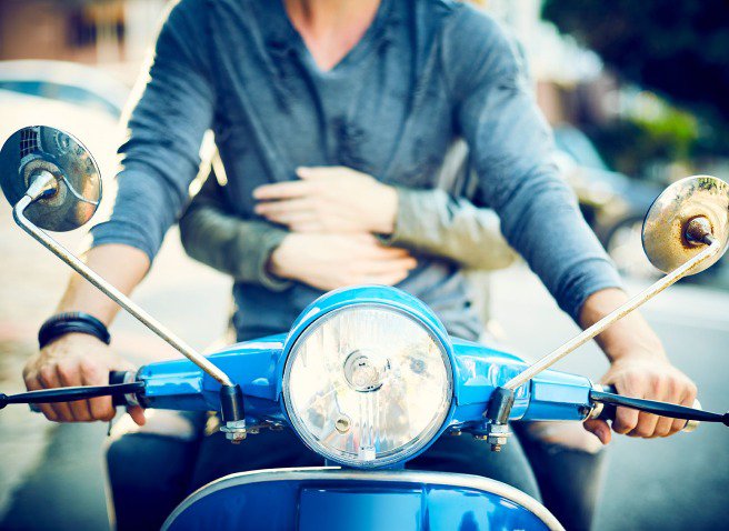 Two people on a scooter - close up detail