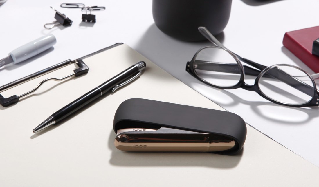 Black and silver IQOS 3 kit on a working desk