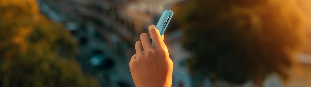 A hand holding Breeze Blue ILUMA i One. 