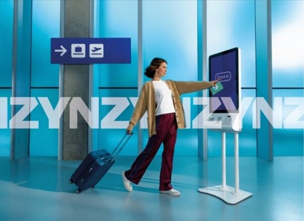 Image of a woman with a suitcase checking in at an airport.