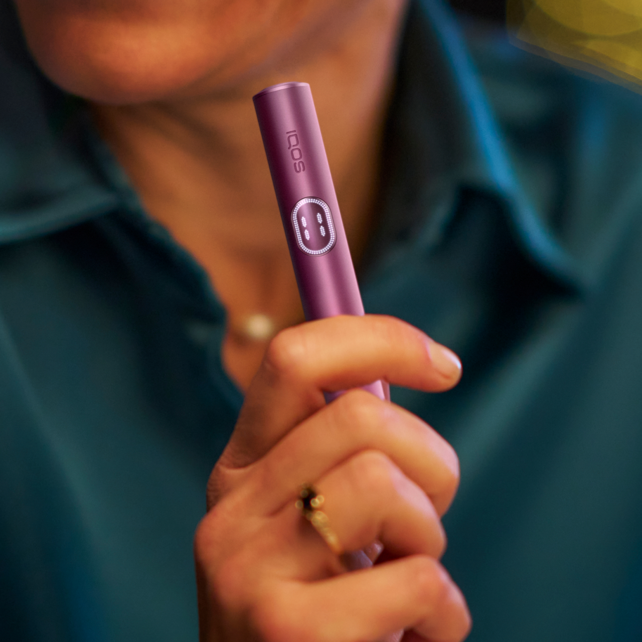 Person hält einen IQOS ILUMA i Holder