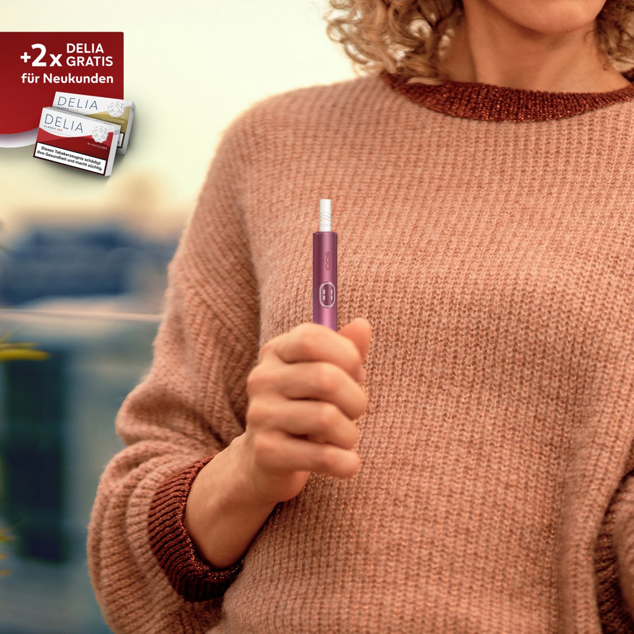  IQOS ILUMA i Tabakerhitzer in der Farbe Garnet Red in Benutzung dargestellt.