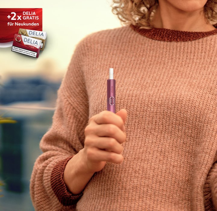 IQOS ILUMA i Tabakerhitzer in der Farbe Garnet Red in Benutzung dargestellt.