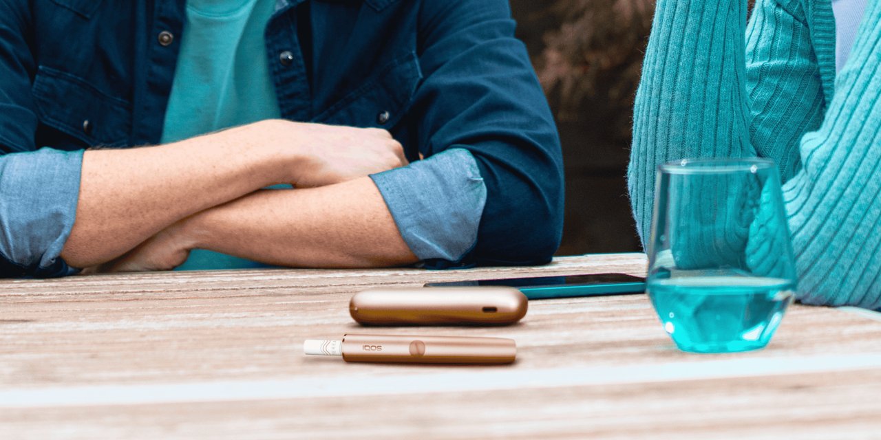 Ein IQOS ILUMA in gold auf einem Tisch